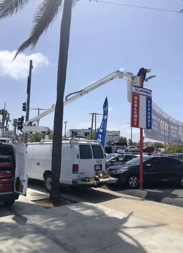 Tamar Electric bucket truck lifting an electrician up to repair a tall business sign in Escondido